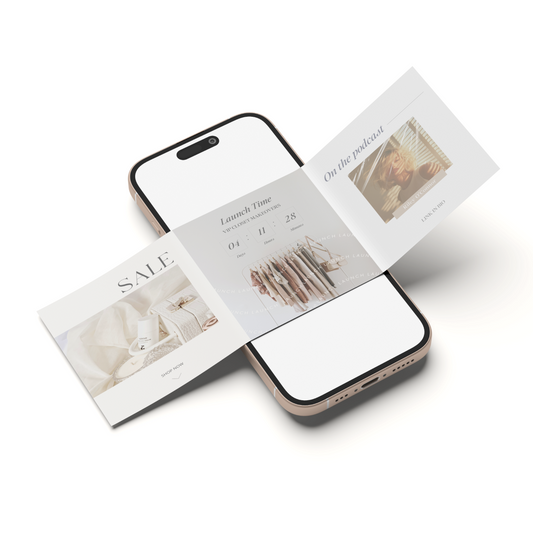 A smartphone with a blank white screen lies on a white surface, crossed by two printed cards or flyers with soft beige and brown lifestyle imagery and text such as SALE and laundry time.